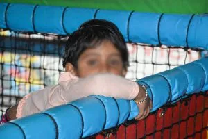 Child looking through play frame netting